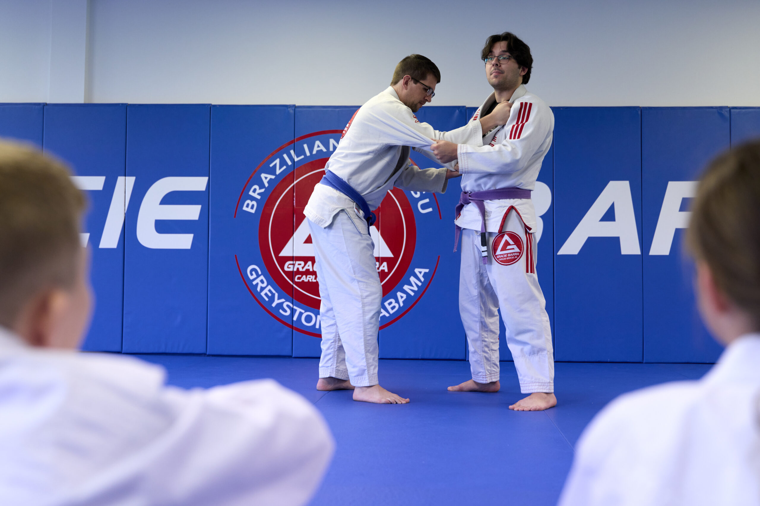 Brazilian Jiu-Jitsu blue belt requirements demonstration with students practicing side control frames on the mat